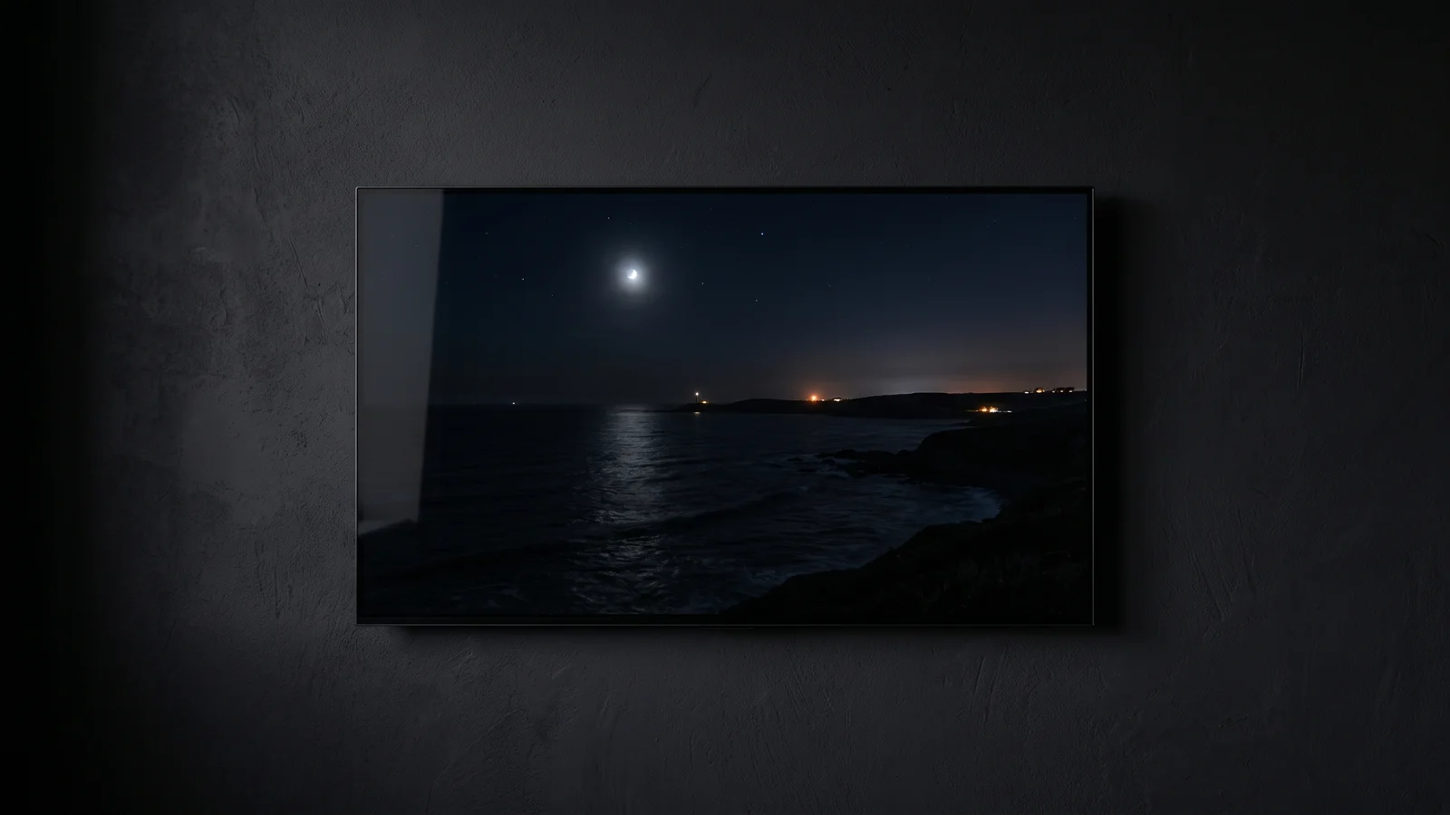 A slim flat-panel television on a dark wall displaying a moonlit coastal night scene with exceptionally deep black levels, evoking the reference black performance Pioneer's Kuro plasma was famous for