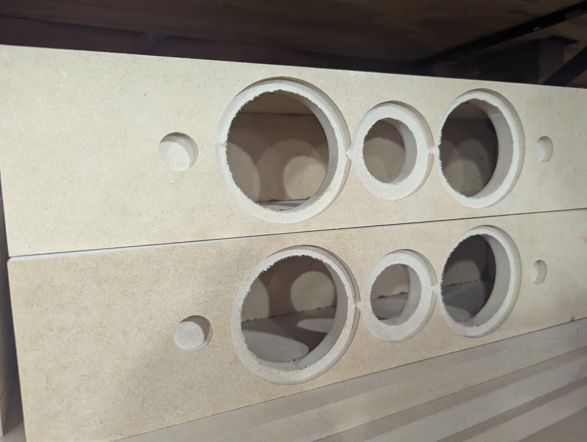 Pair of CNC-cut speaker baffles with driver and tweeter cutouts ready for assembly