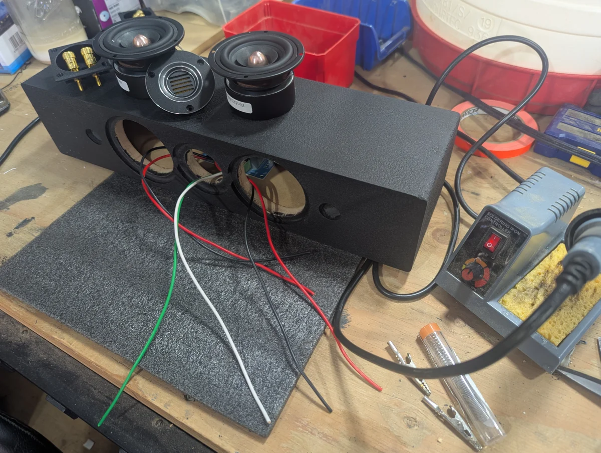 WubWub Audio surround speaker being hand-wired and soldered on workshop bench