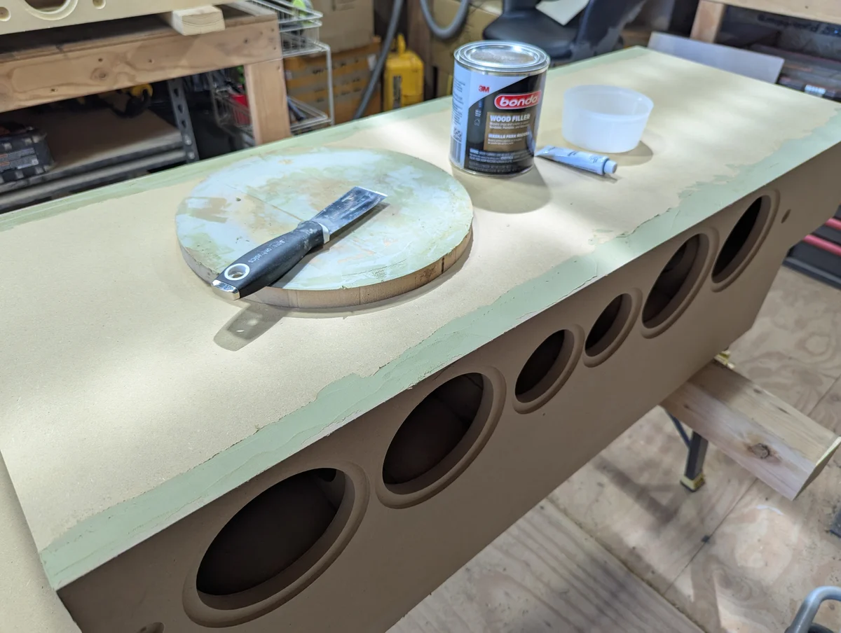 Center channel speaker cabinet being filled and prepped for textured finish