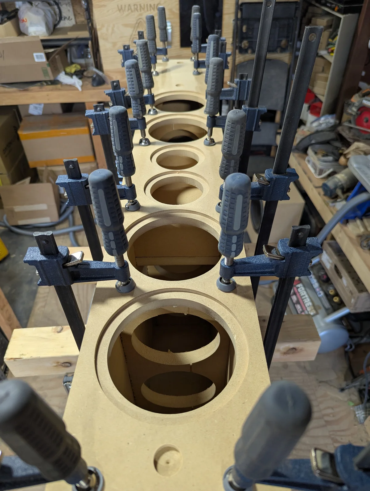 Tower speaker cabinets being glued and clamped during assembly in Arizona high desert workshop