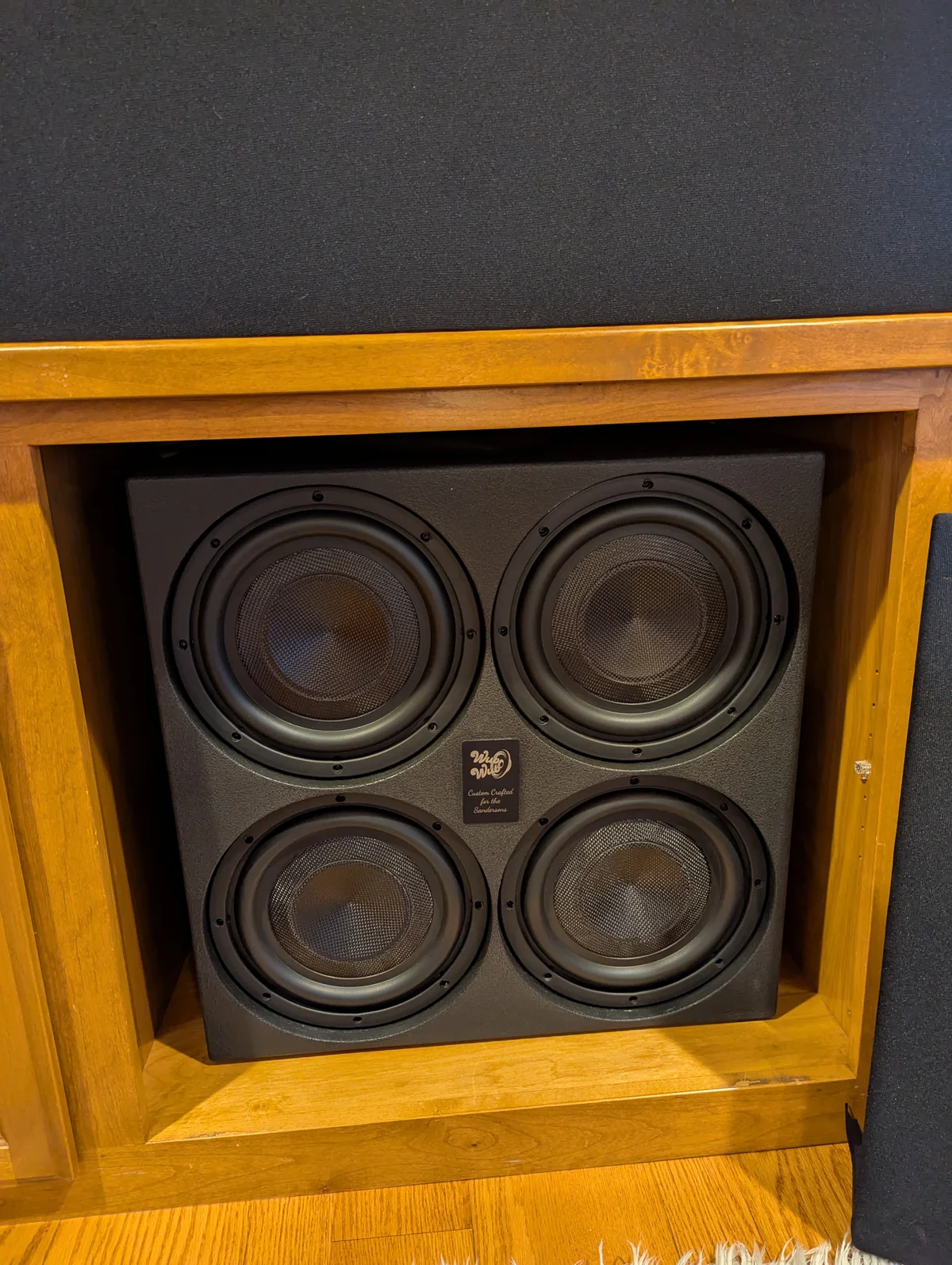 Close-up of WubWub Audio branded quad subwoofer with four drivers installed in home theater cabinet