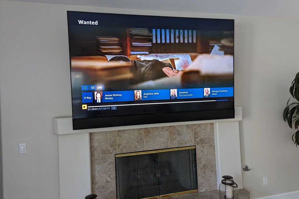 Large format TV and custom audio system installed above fireplace mantle in Paradise Valley Arizona home